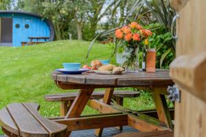 a picnic table with food and a vase of flowers at 1 Bed in Bude oc-s34856 in Bude