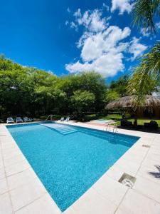 a swimming pool with blue water and trees at Posada La Ernestina Villa de las rosas in Villa Las Rosas