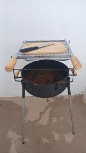 a grill with two cooking utensils on top of it at Casa Tranquila com Vaga para carro em Três Lagoas in Três Lagoas