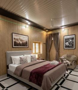 a bedroom with a large bed and a chair at Vaishno Atithi Bhawan in Naimishāranya