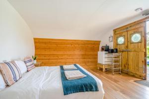 a bedroom with a large white bed and a wooden wall at 1 Bed in Bude oc-s34850 in Bude +17 photos