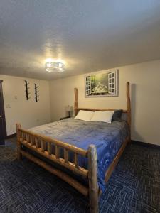 a bedroom with a wooden bed with a blue comforter at Salt River Lodge in Thayne