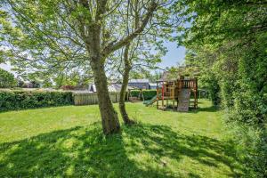 a tree in a yard with a playground at 1 Bed in Bude oc-s34846 in Bude +21 photos