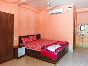 a bedroom with a bed with red pillows at Hotel Rajlaxmi in Neil Island