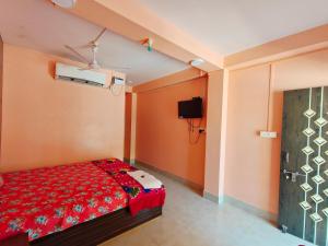 a bedroom with a bed with a red comforter at Hotel Rajlaxmi in Neil Island