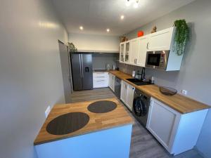a kitchen with white cabinets and a wooden counter top at Maison Casa Nord du Portugal Gères in Arcos de Valdevez