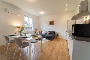 a kitchen and living room with a table and a couch at Au 212, T2 moderne et confortable in Mont-de-Marsan