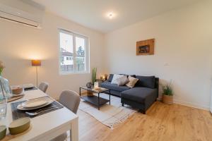 a living room with a couch and a table at Au 212, T2 moderne et confortable in Mont-de-Marsan