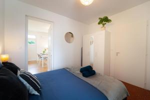 a bedroom with a bed with a blue pillow on it at Au 212, T2 moderne et confortable in Mont-de-Marsan +19 photos