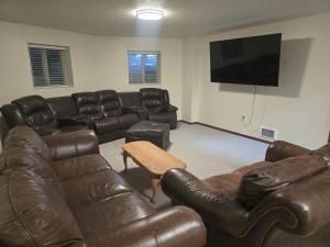 a living room with leather furniture and a flat screen tv at Salt River Lodge in Thayne