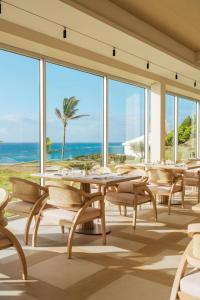 a dining room with tables and chairs and the ocean at Azura Bermuda in Bermuda