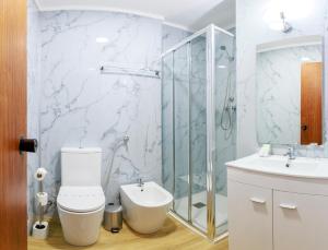 a bathroom with a toilet and a shower and a sink at São Roque Suites in Bragança