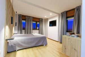 a bedroom with a bed and some windows at São Roque Suites in Bragança