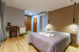 a bedroom with a bed with two towels on it at São Roque Suites in Bragança +15 photos