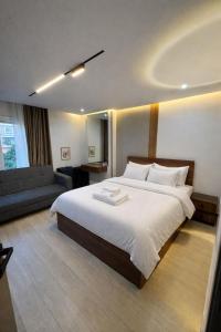 a bedroom with a large bed and a couch at Luxury 2BR Pool View Apartment Hotel Style in New cairo