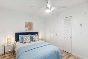 a bedroom with a blue bed and a ceiling fan at Bright 2BR Oceanview Condo in Key West