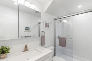 a white bathroom with a sink and a shower at Bright 2BR Oceanview Condo in Key West