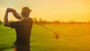 a man swinging a golf club in a field at Blue Mist Motel Florence in Florence