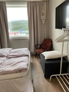 sypialnia z łóżkiem, telewizorem i krzesłem w obiekcie Leilighet Hemnesberget- Sørlandsvegen 15 B w mieście Hemnesberget