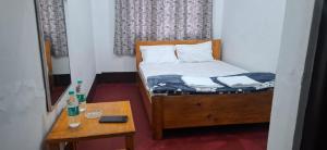a small room with a small bed and a table at Tranquil River Nest in Rupa