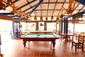 a pool table in a room with tables and chairs at Hotel Campestre San Fernando in La Paloma