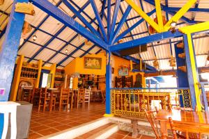 a room with a restaurant with tables and chairs at Hotel Campestre San Fernando in La Paloma