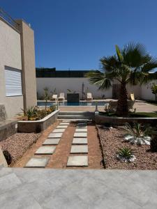 a garden with a stone walkway in front of a building at Villa oasis in Houmt Souk