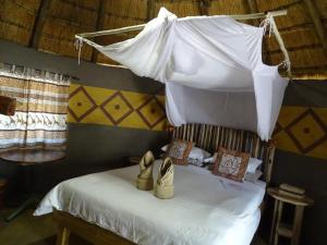 a bedroom with a bed with shoes on it at Discovery Bed and Breakfast in Maun