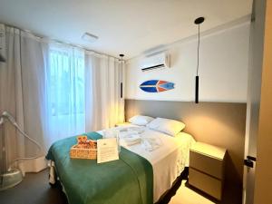 a bedroom with a bed with a book on it at Sofisticado 2Q 200m do Mar 1 min do Centrinho in Porto De Galinhas