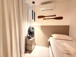 a small room with a bed and a fan at Sofisticado 2Q 200m do Mar 1 min do Centrinho in Porto De Galinhas