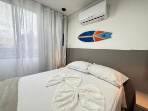 a bedroom with a bed with a white bow on it at Sofisticado 2Q 200m do Mar 1 min do Centrinho in Porto De Galinhas
