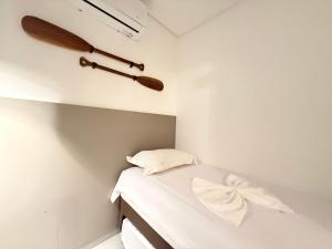 a small bedroom with a bed with white sheets at Sofisticado 2Q 200m do Mar 1 min do Centrinho in Porto De Galinhas +47 photos