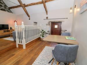 a living room with a wooden table and chairs at Beudy Bach in Llanbedr