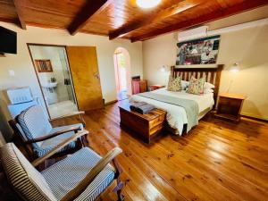 a bedroom with a bed and a chair and wooden floors at Travalia Guest Farm in Nelspoort