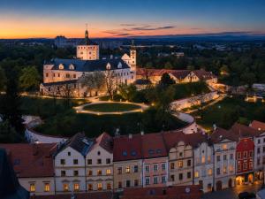 Blick auf ein Gebäude in einer Stadt bei Sonnenuntergang in der Unterkunft Hotel 100 in Pardubice