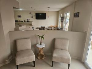 a kitchen with two chairs and a counter with a table at Hotel palma de oro in Puerto Peñasco