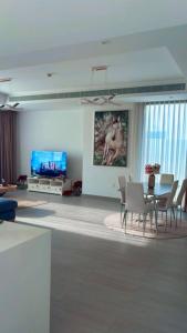 a living room with a table and chairs and a tv at Home Sweet Home in Abu Dhabi
