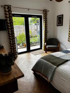 a bedroom with a bed and a window with a chair at Barnfield house in Upham