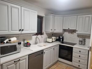 a white kitchen with white cabinets and appliances at Large Holiday Apartment Enniscrone in Enniscrone