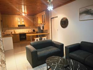 a living room with two couches and a kitchen at Le Cape Nest Guest House in Parow