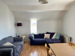a living room with a blue couch and a table at Large Holiday Apartment Enniscrone in Enniscrone