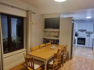 a kitchen and dining room with a wooden table and chairs at Large Holiday Apartment Enniscrone in Enniscrone +1 photo