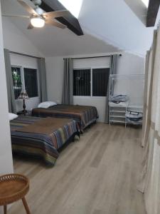 a bedroom with two beds and a ceiling fan at Casa Magnolia in El Socorro