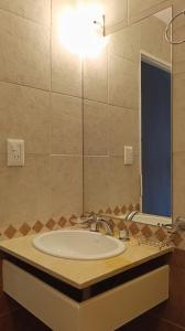 a bathroom with a sink and a large mirror at Hotel Cafayate Design in Cafayate