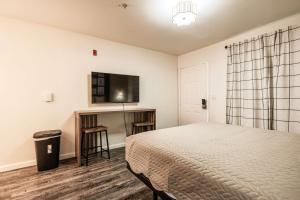 a bedroom with a bed and a flat screen tv at Chic AZ Studio Travel Nurses Welcome in Cashion