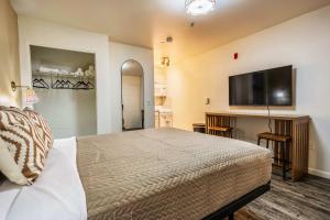 a bedroom with a bed and a flat screen tv at Chic AZ Studio Travel Nurses Welcome in Cashion