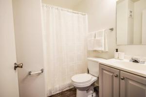 a white bathroom with a toilet and a sink at Chic AZ Studio Travel Nurses Welcome in Cashion +26 photos