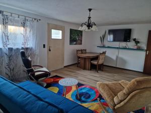 a living room with a blue couch and a table at Ferienzimmer-Monteurzimmer in Sibbesse