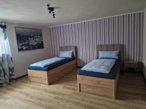 two twin beds in a room with striped walls at Ferienzimmer-Monteurzimmer in Sibbesse
