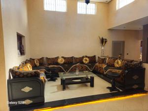 a living room with couches and a coffee table at Villa du bonheur Chambres d'hote in Ouled el guerne